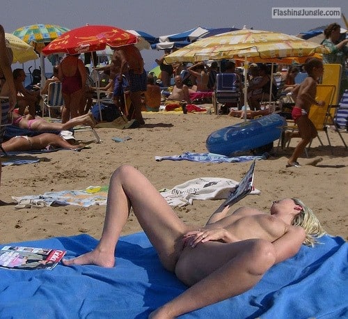 Voyeur Pics Nude Beach Pics - Blond girl masturbating on beach while reading a sex magazine