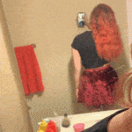 Redhead pulling up red skirt to flash ass in fishnets