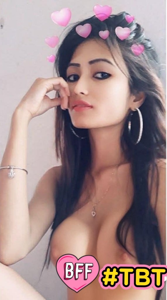 Hotwife Pics: Midday Tease: A Glimpse of Intimacy A woman in a bra and hoop earrings stands with a neutral expression, fingers touching her cheek. Text overlays and pink hearts add personal context, hinting ...