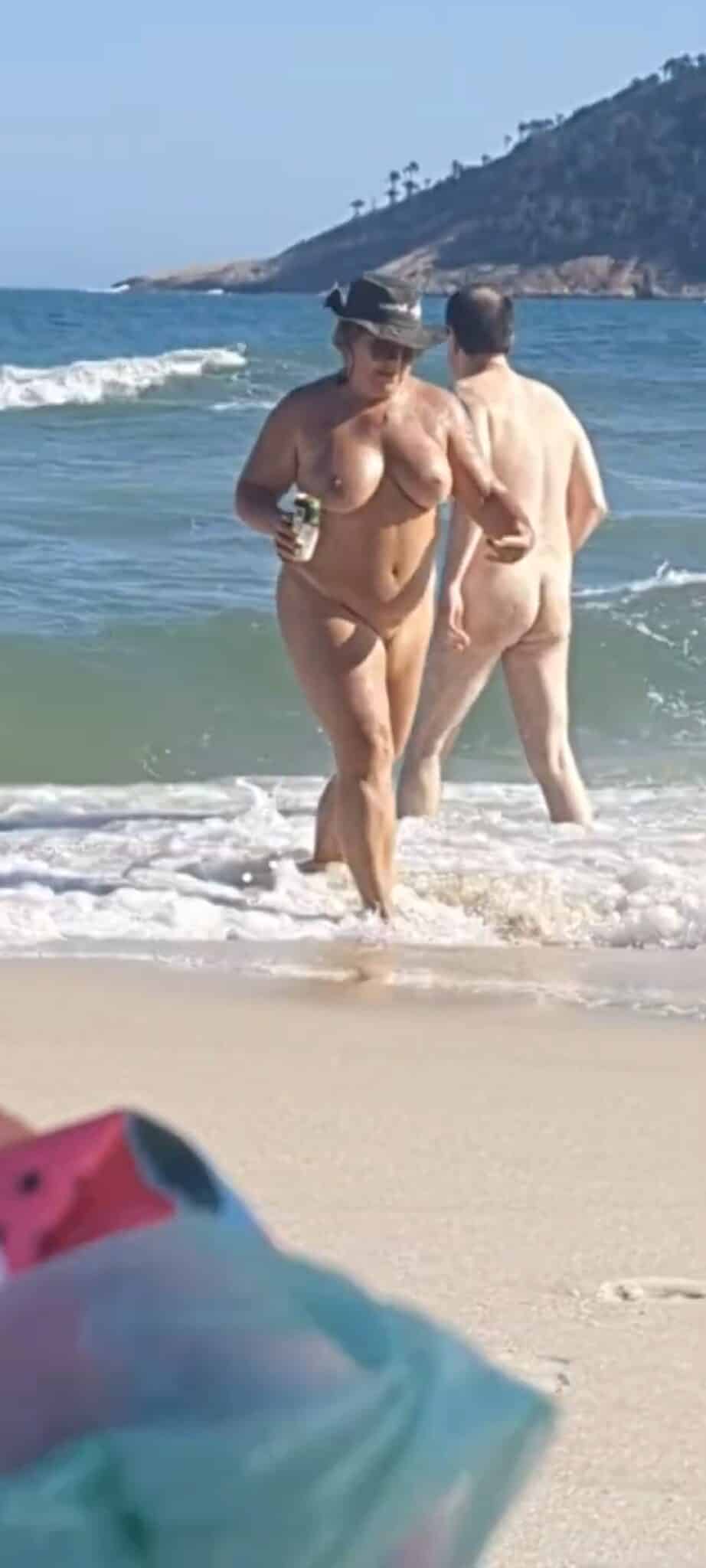 milf gif - Can a MILF Get Away with Nudity on a Public Beach? A nude MILF and man stand confidently in shallow ocean waves on a public beach, fully exposed and unapologetic in their nudity, challenging societal norms. - Ass Flash Pics