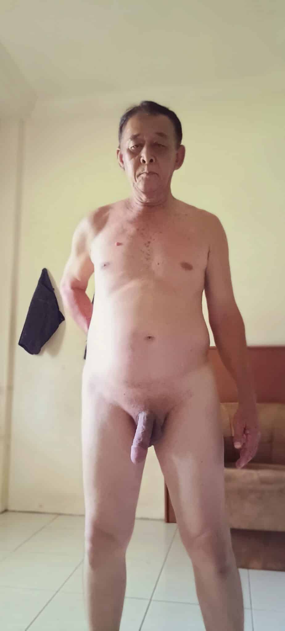 nude flashing - John Dee’s Casual Nude Pose John Dee stands nude in his bedroom, displaying a casual, unapologetic pose with a direct gaze and soft, uncut cock. - Boobs Flash Pics