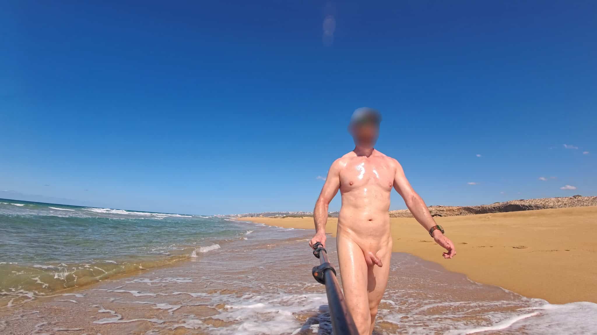 jb nn  nude cunt pics - Naked Stroll: Unofficial Nude Beach Encounter A man captures a selfie at an unofficial nude beach, showcasing public nudity with a watch on his wrist and a selfie stick in hand. - Dick Flash Pics
