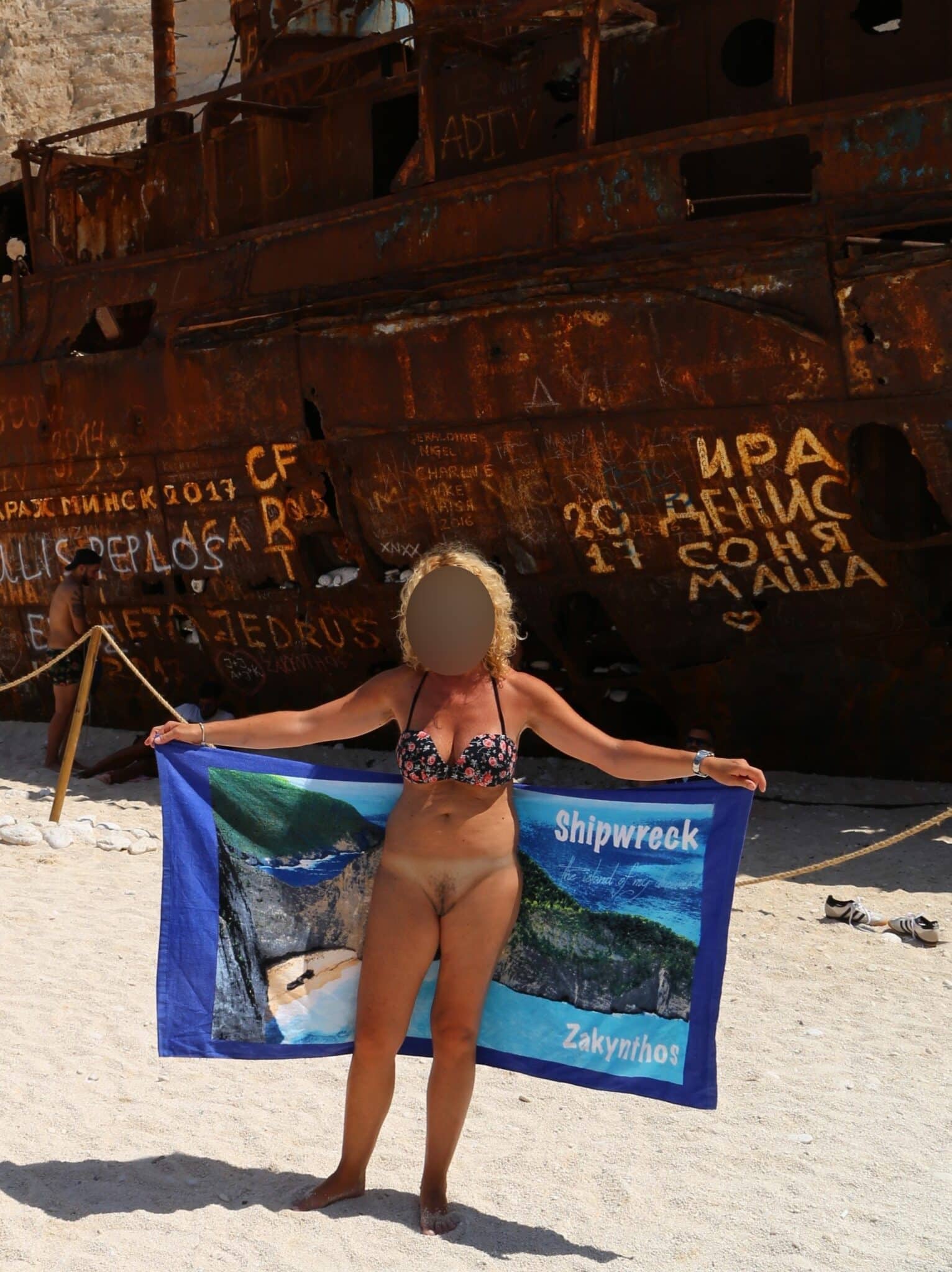 Bitch Flashing Pics: Mature Blonde Bitch Flashes Her Natural Bush on Zakynthos Beach Mature blonde woman flashes her natural bush on a public beach in Zakynthos, standing confidently with a towel barely covering her thighs. The scene captures...