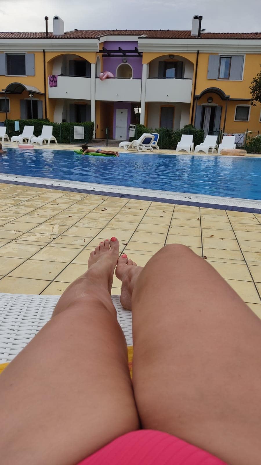 hotwife pics - Poolside Tease: Hotwife Sunbathing A hotwife sunbathing poolside in a pink bikini, exuding confidence and allure. Smooth thighs and a tantalizing glimpse of her curves draw attention. - Hotwife Pics