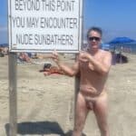 What Does a Nude Man Pointing at a Sign on a Beach Say About Public Nudity?