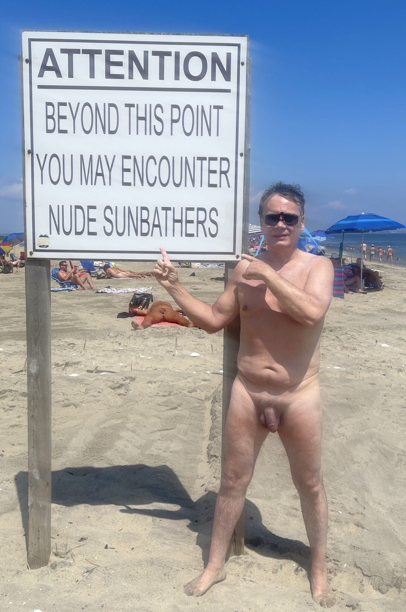 jennifer lopez nude ass pics - What Does a Nude Man Pointing at a Sign on a Beach Say About Public Nudity? A nude man on a beach points at a sign warning of nude sunbathers, highlighting the power dynamic of public nudity. - Dick Flash Pics